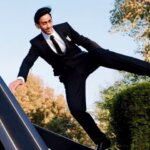 a gentleman doing a parkour jump wearing black suits and youtube logo