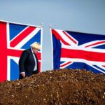 Boris johnson waving a union jack flag, standing on a smoking pile of horse manure